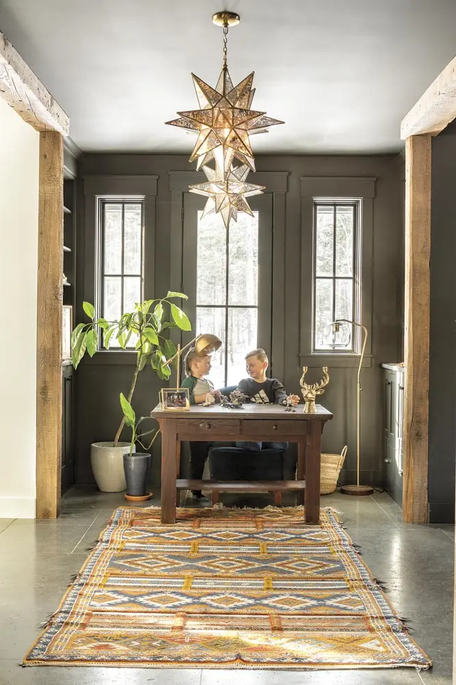 a Moroccan Berber rug, an antique walnut table, and Moravian-star pendants
