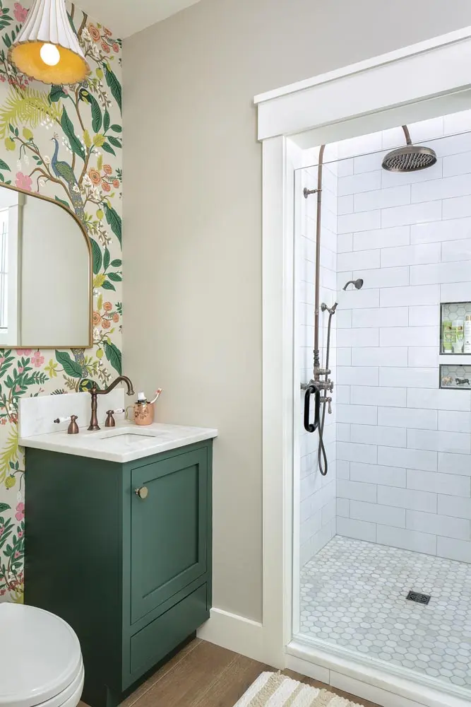 a bathroom featuring a custom vanity in Hunt Club, by Sherwin- Williams, a Target mirror, and a terra-cotta fixture from Circa Lighting.