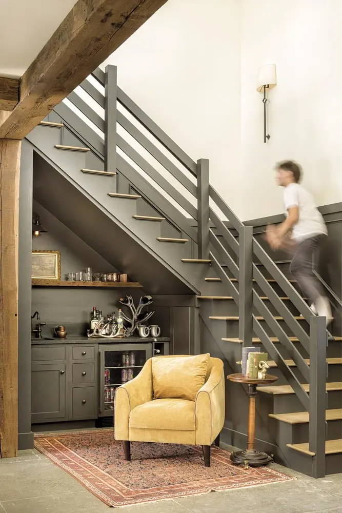 Beneath the stairs, a bar area with a silver-plated “antler” wine rack, a Victorian-era walnut table from Pillars, and a Kilim from Falmouth’s Araby Rug Galleries