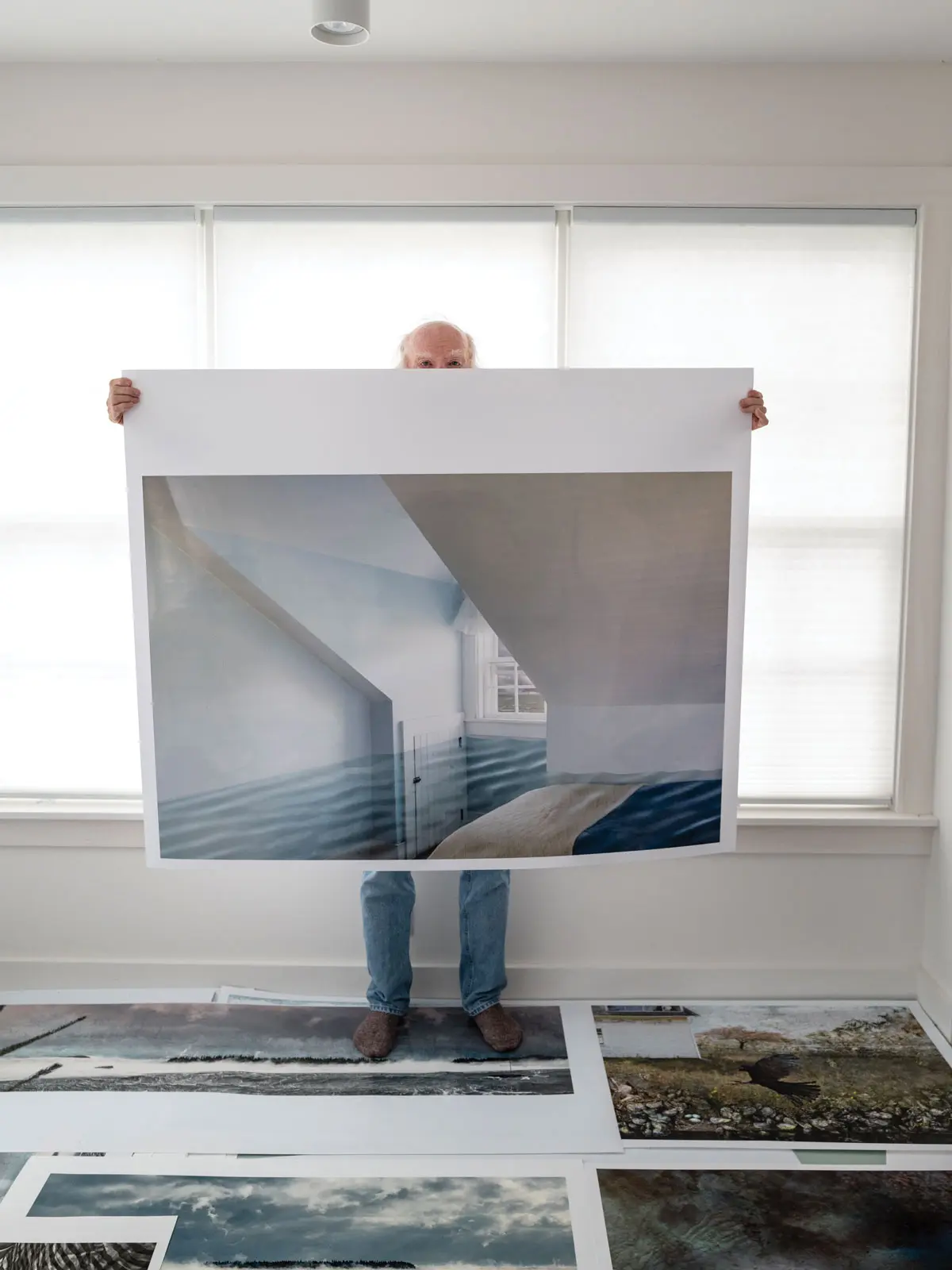 Jeffery Becton holding up a print of "Olivia's Room," one of his photomontages