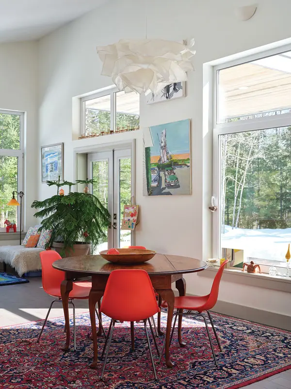 An IKEA pendant hovers cloud-like over an antique table from the Sears, Roebuck and Co. catalog and Eames- style chairs in the dining room