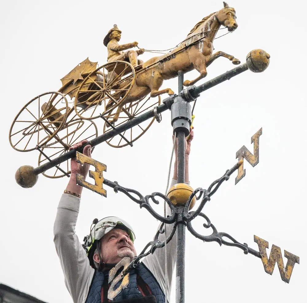 Pinnacle Tree owner Harry Wolfington works to remove the weather vane Thursday April 6, 2023 at the Second Street building that used to be home of Hallowell Fire Department.