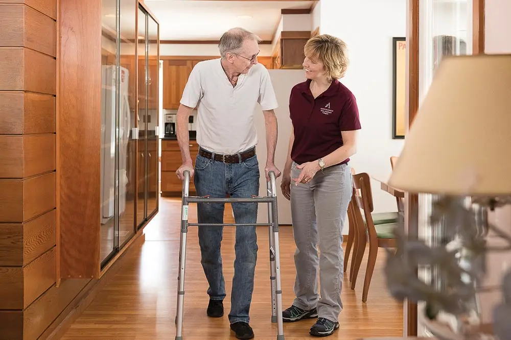 Androscoggin Home Healthcare and Hospice employee assisting man with walker
