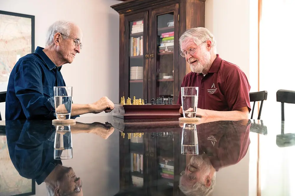 Androscoggin Home Healthcare and Hospice employees playing chess with a patient
