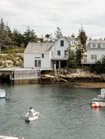 Artist Bo Bartlett rows his skiff, the Conrad K, in Matinicus Harbor toward Wheaton Island