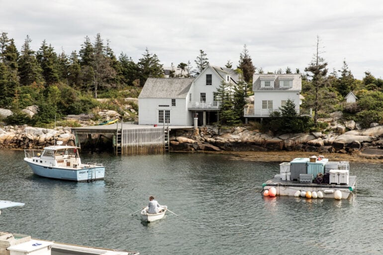 Artist Bo Bartlett rows his skiff, the Conrad K, in Matinicus Harbor toward Wheaton Island