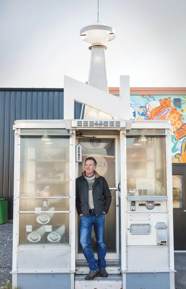 Developer Chris Thompson in front of a retro-futuristic faux toy store by Randy Regier and a mural by Spenser Macleod at Thompson’s Point.