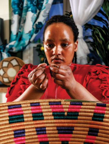Ange Muhorakeye working on one of her handwoven baskets