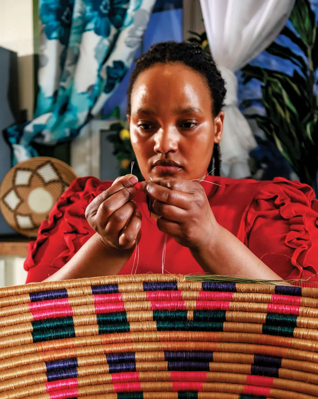 Ange Muhorakeye working on one of her handwoven baskets
