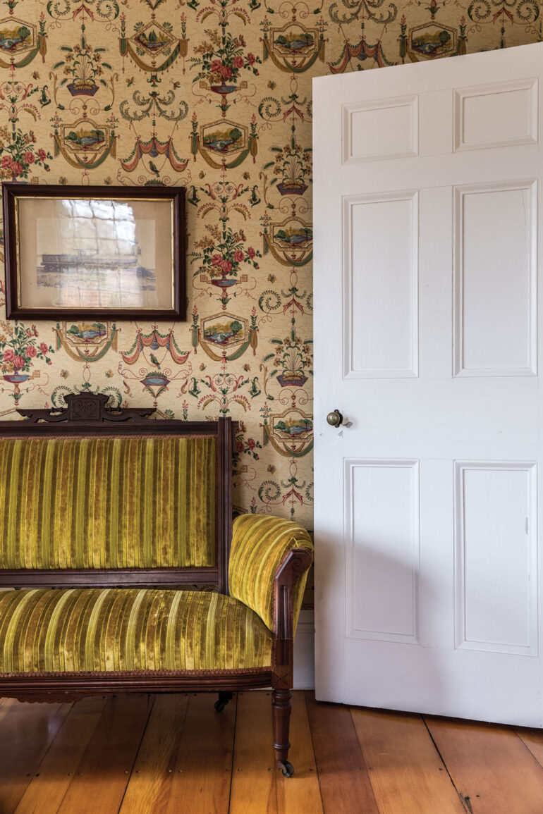 A Victorian-era settee sits beneath a circa-1860 photograph of a Grand Trunk Railroad steam locomotive built by the Portland Company in Harpswell's Captain Johnson H. Stover Jr. House