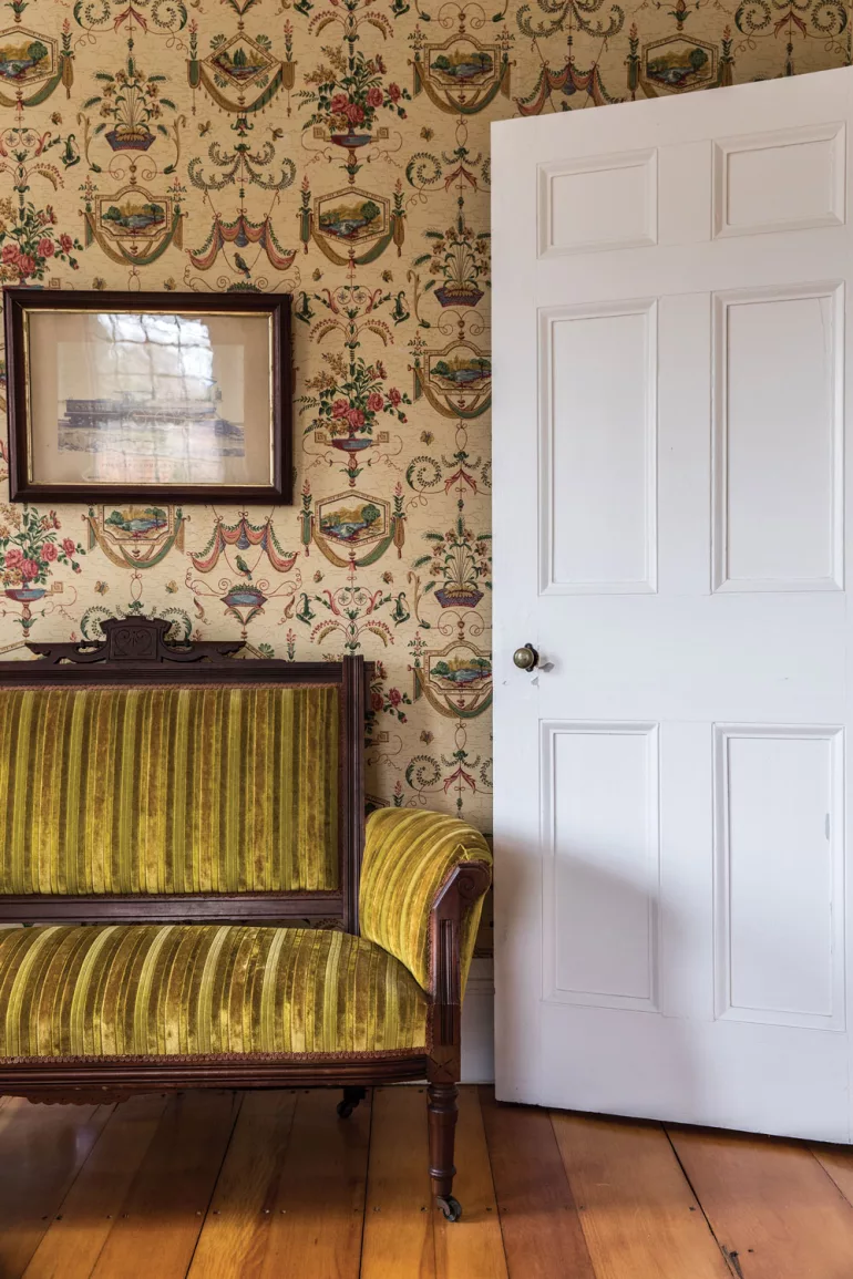 A Victorian-era settee sits beneath a circa-1860 photograph of a Grand Trunk Railroad steam locomotive built by the Portland Company in Harpswell's Captain Johnson H. Stover Jr. House