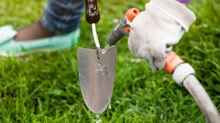 gardener hosing down trowel