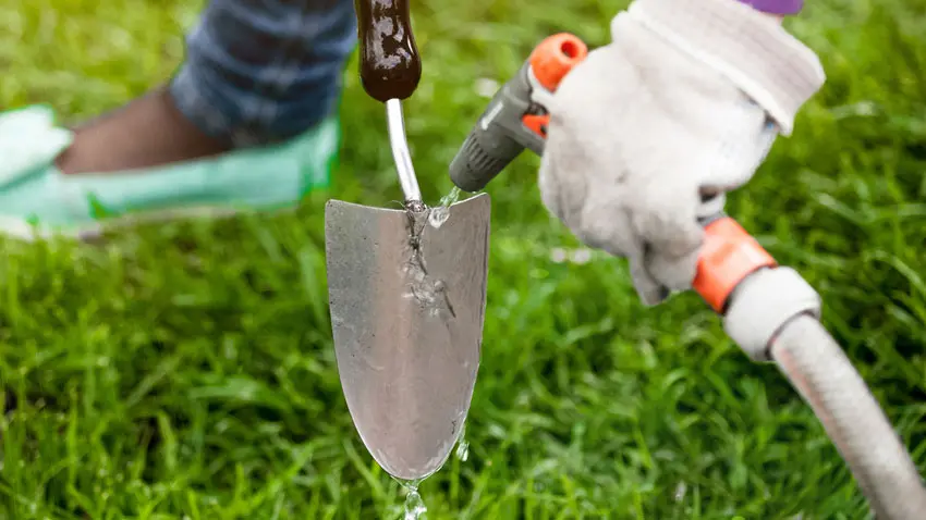 gardener hosing down trowel