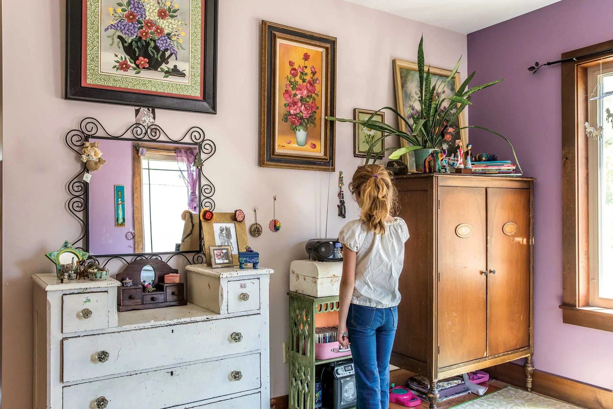 a bedroom with two shades of purple paint — Ancestral Haze by Valspar and Pale Plum by Olympic — and flower paintings