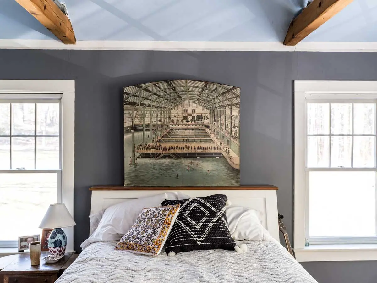 This Schoolhouse Rocks! The guest room pairs walls in Benjamin Moore’s Dior Gray with a rather heavenly sky-blue vaulted ceiling strewn with clouds that Juliana McClain painted for her daughter.