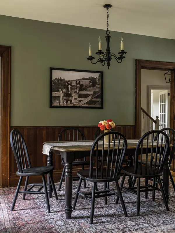Sherwin-Williams’s Evergreen Fog on the walls complements the original dark maple trim and wainscoting in the dining room