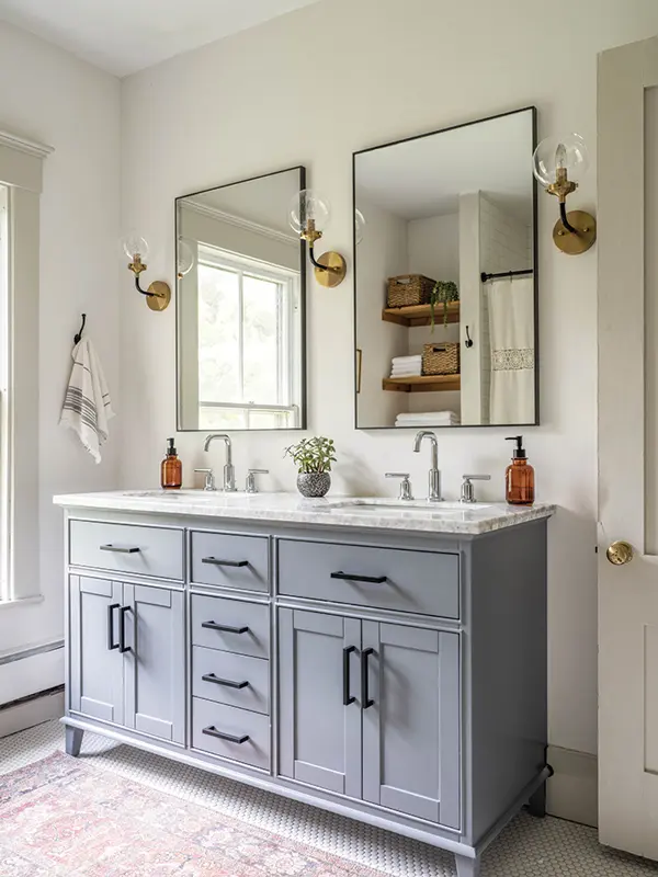 Rectangular Crate & Barrel mirrors and spherical sconces from Home Depot create an artful geometry above a vanity from Portland’s Habitat for Humanity ReStore in the bathroom