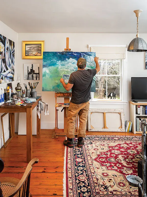 David DesFosses set up his easel and supplies in the living room, which serves as a home studio