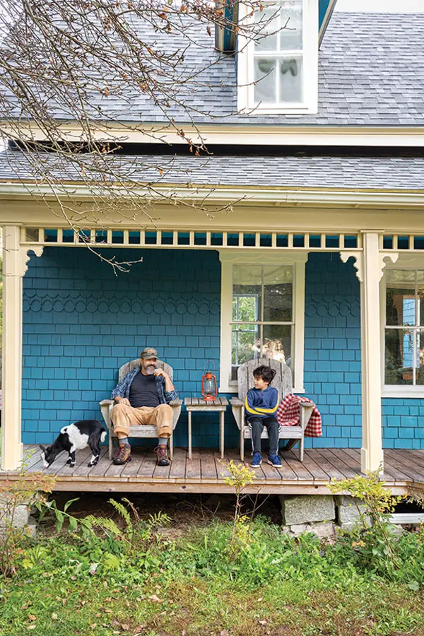 David DesFosses, pictured with our photographer’s son and one of the Nigerian Dwarf goats he once owned on the home's crooked porch