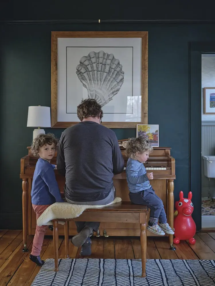 Patrick Krulik plays the piano with his children in the music room