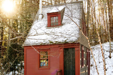red, snow-covered camp in Alna, Maine
