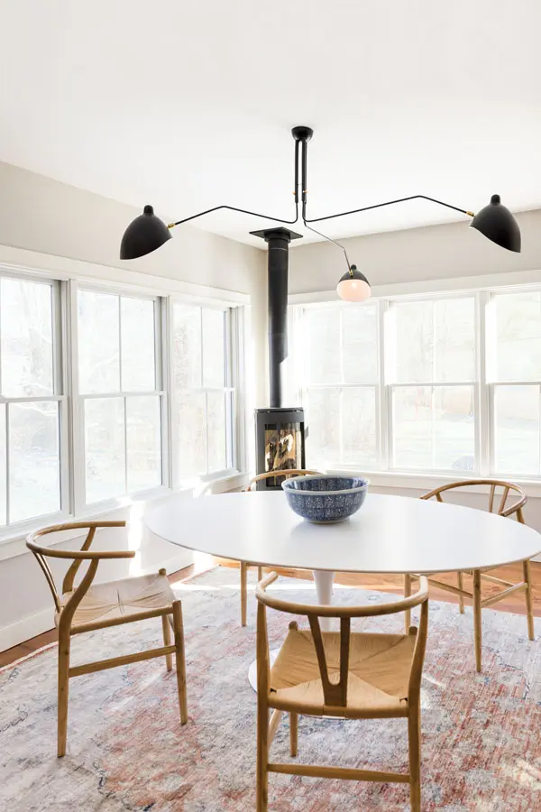 a mod Serge Mouille–style fixture above a Saarinen dining table