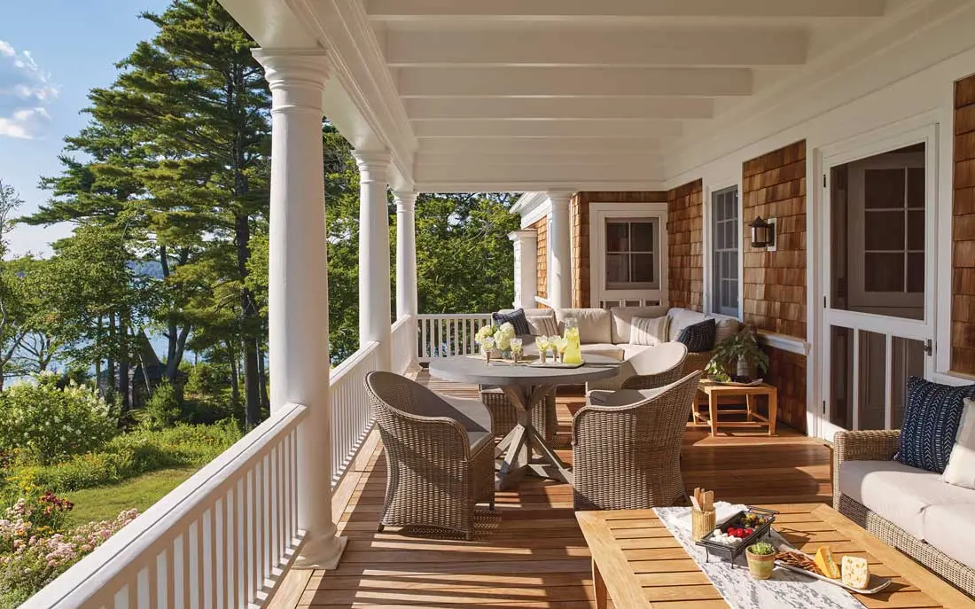 This west-facing porch received new ipe decking and all-weather-wicker furnishings; at left is a German-style garden house installed by the estate’s original owner, Samuel Houston.