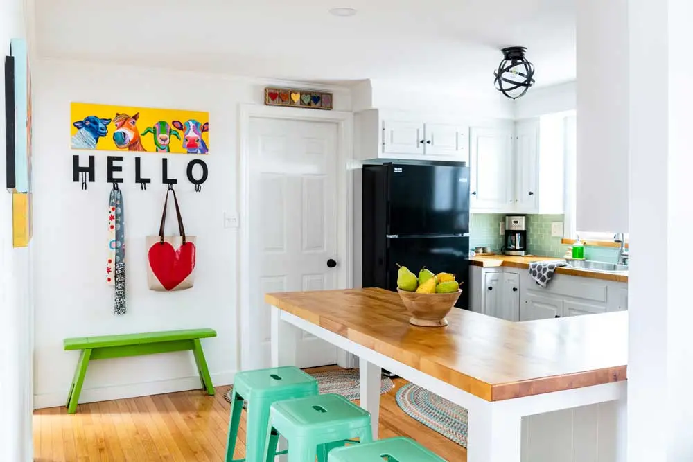 How a House-Flipping Project Became Their Home An L-shape peninsula Mike built with birch butcher block atop a maple base solved the problem, while stools and Glacier glass subway tile sport Julie’s beloved seafoam.