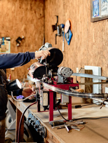 Gus Fillebrown sharpening a saw blade at Complete Sharpening Service in Bridgton, Maine