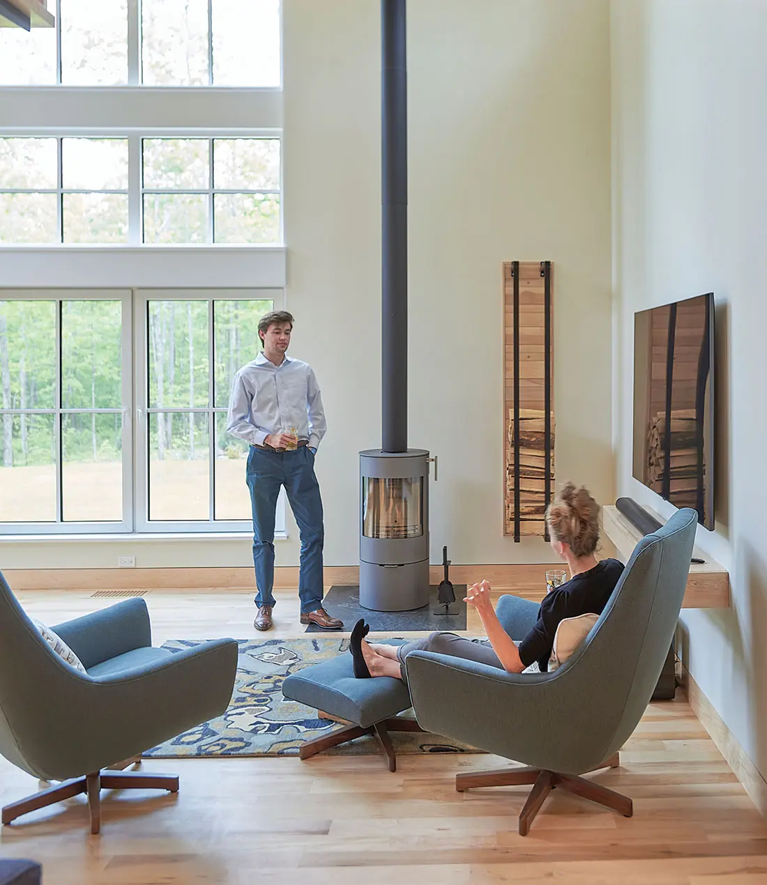 Dreaming of Building a Green Retreat? A RAIS woodstove pipe scales the living room, which has a carpet from Bradford’s Rug Gallery in Portland.