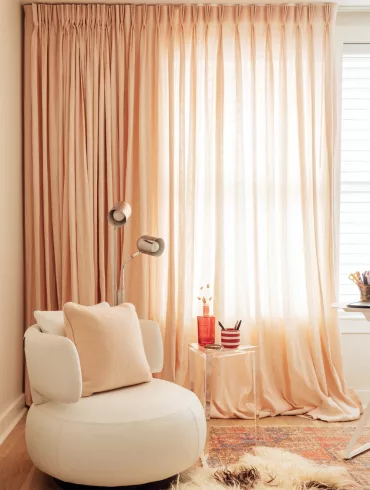 Home Remedies client Cathy Roach layered linen curtains over sheer shades in her bedroom.