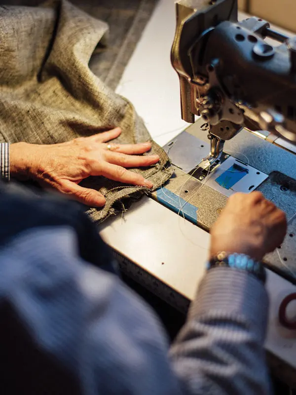 upholstery designer sewing a custom curtain on an industrial sewing machine