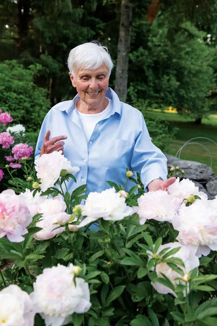 MHSpring2021_garden2 Linda Faatz takes a moment to enjoy a few of the many peonies that ring the Courtyard Garden.