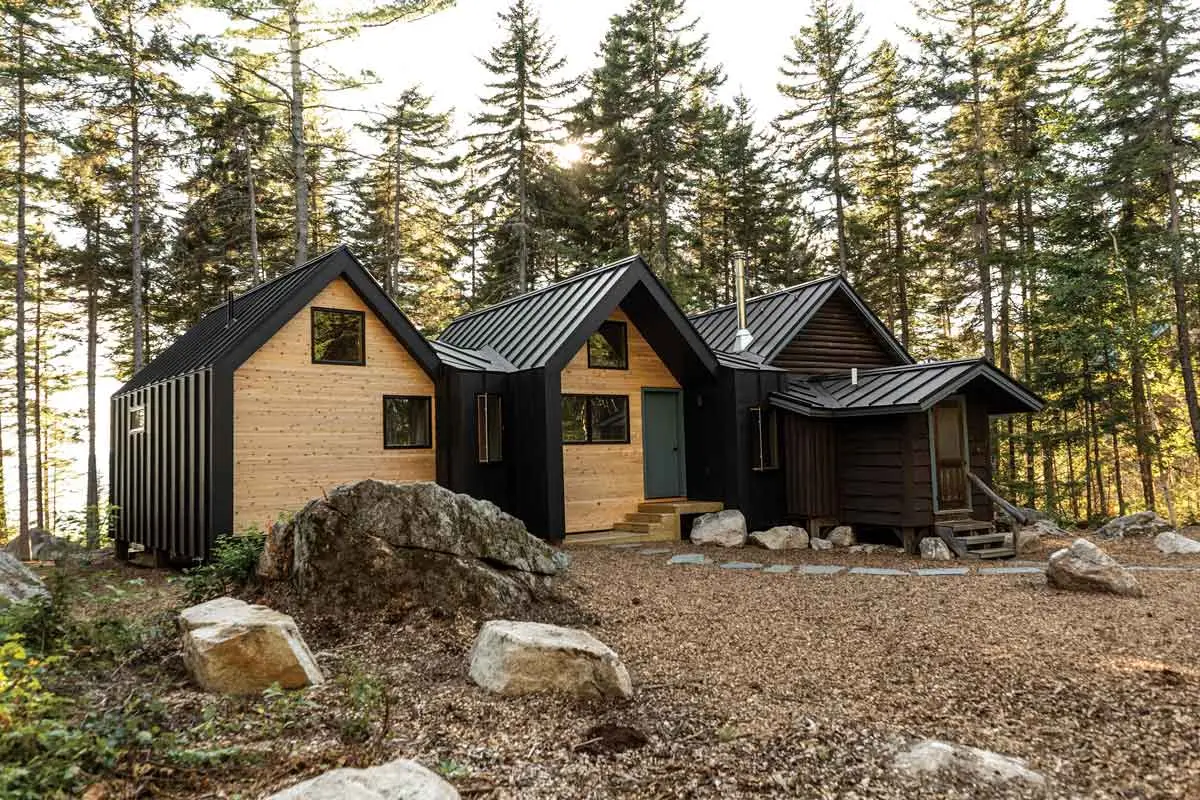 architect Jocelyn Dickson's Oquossoc cabin expansion includes two new modern cabins attached to one side of the property's original log cabin