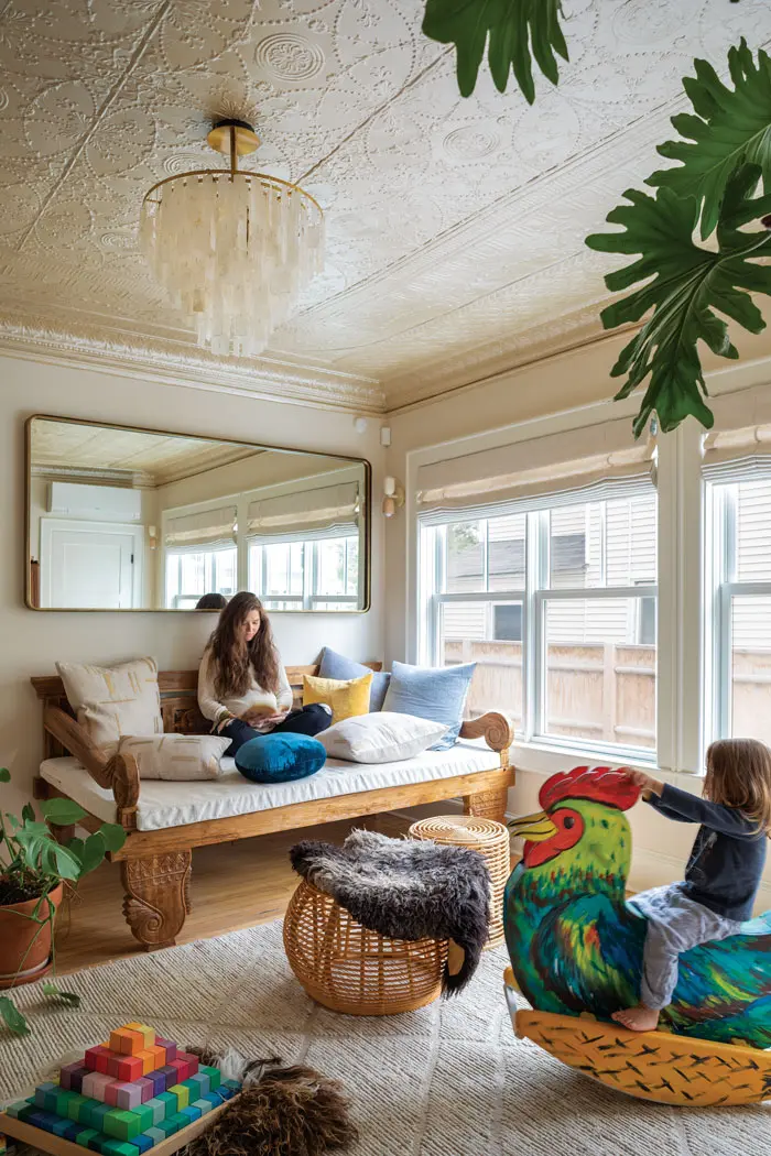Mackenzie Maher-Coville sitting in her remodeled Portland second empire living room