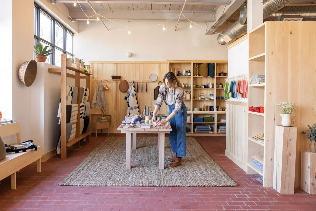 Wood-handled tools; maple cutting boards; stoneware dishes; gingham linens; copper watering cans; tapers by Rockport’s Danica Design Candles; custom quilts by Yarmouth’s Smith’s General; and co-owner Katie Bowes await at The Post Supply, in Portland.