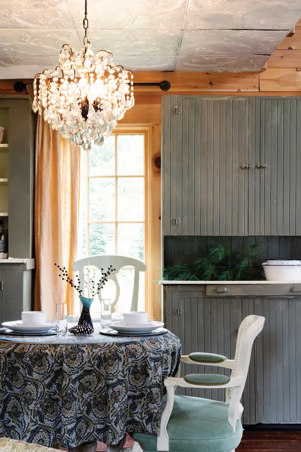 a 1920s chandelier hangs over the dining room table