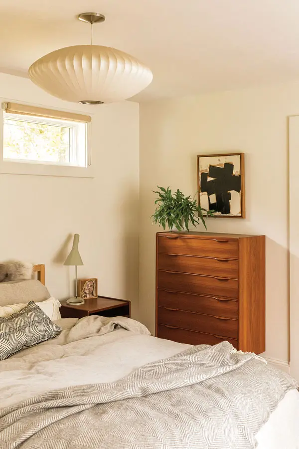 In their bedroom, a teak Henning Jørgensen dresser pops, while a George Nelson Bubble lamp recedes into the room’s neutral walls.