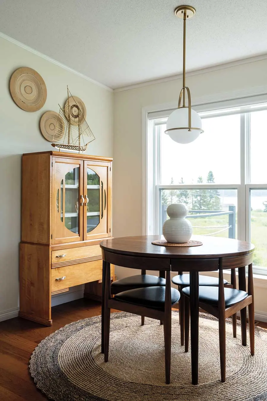 An Art Deco cabinet from Old Creamery Antique Mall in Ellsworth and a Hans Olsen Roundette table grace the pine-sided main cottage