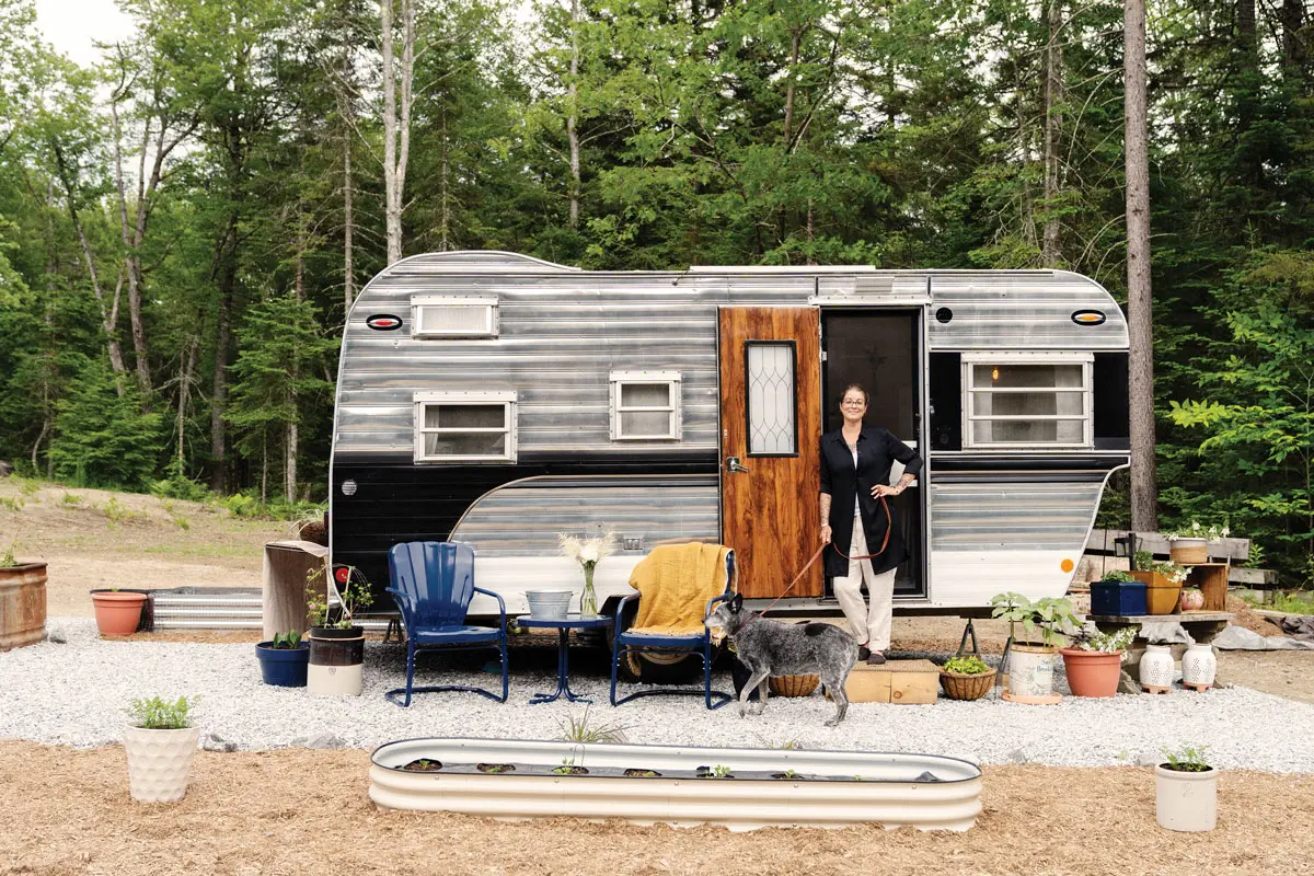 Katrina Kelley standing in the doorway of her vintage-camper-turned-mobile-boutique for her business, Amphitrite Linens
