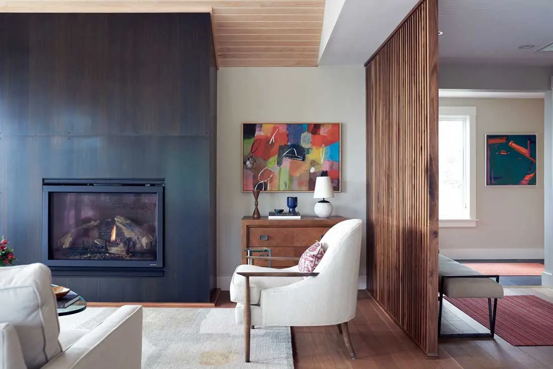 kaucic1 A custom walnut screen separates Louis Kaucic and Billy Merritt’s Cape Elizabeth great room — furnished with a blackened-steel fireplace, wool-and-silk carpet
