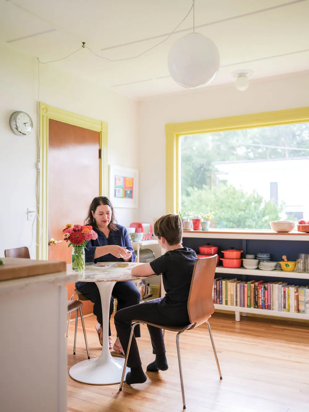 Julianne Gilland and her 14-year-old son, Sam, sit at the kitchen’s Saarinen dining table