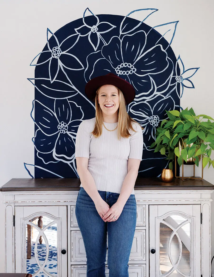 Abigail Hanks in front of a blue and white flower mural