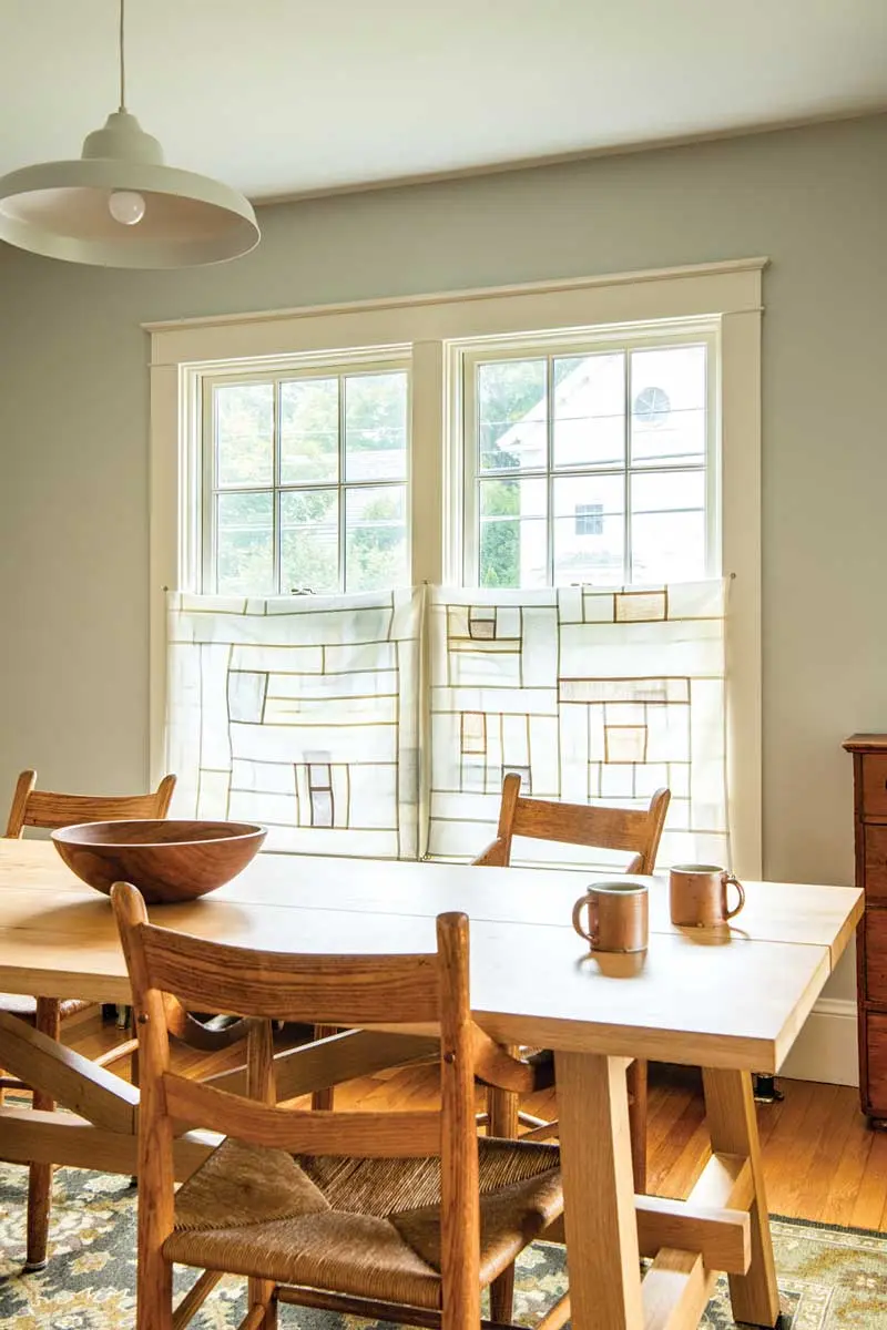 Linen curtains inspired by ancient Korean patchworks hang in the dining room