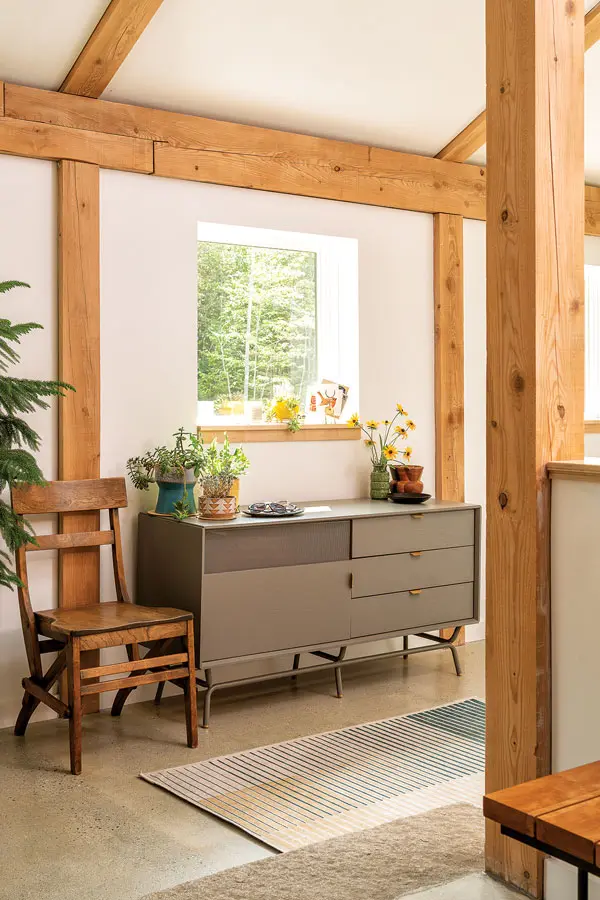a Blu Dot console juxtaposes with a vintage oak chair in the entry