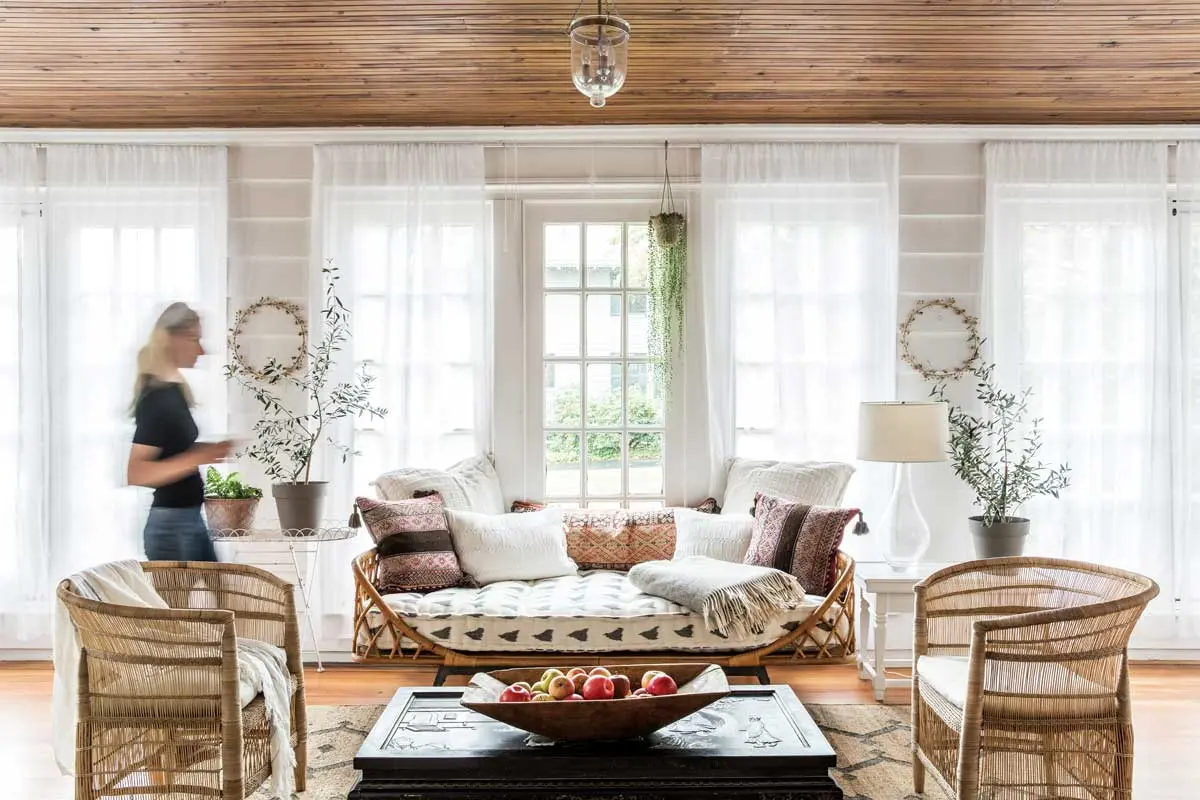 Louis XV/XVI Style Reigns in This Falmouth Home An inherited Chinoiserie coffee table inspired the relaxed beauty of Dominique and Billy Sauer’s three-season porch, furnished with a rattan daybed and a Moroccan-style sisal rug, both from Anthropologie, and vintage pillows from Massachusetts’s Brimfield flea market.