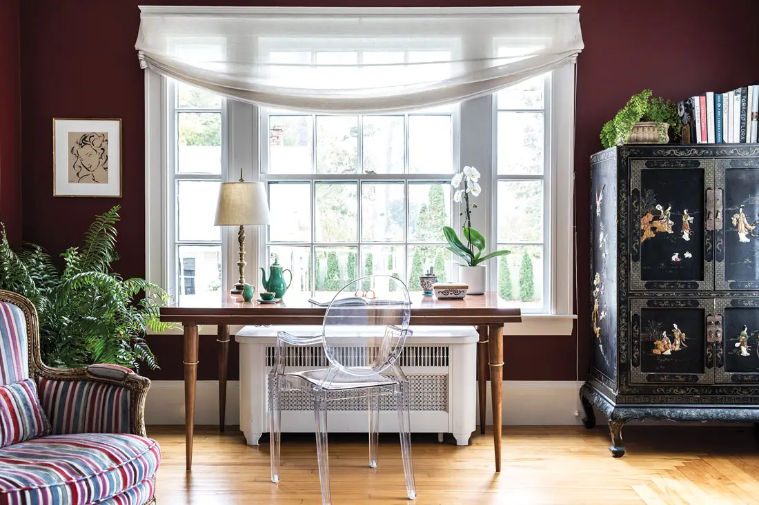 A Philippe Starck Louis Ghost chair adds wispy dimension to the living room, which also features a 1950s-era Italian rosewood desk from 1stDibs and an antique Louis XV armchair.