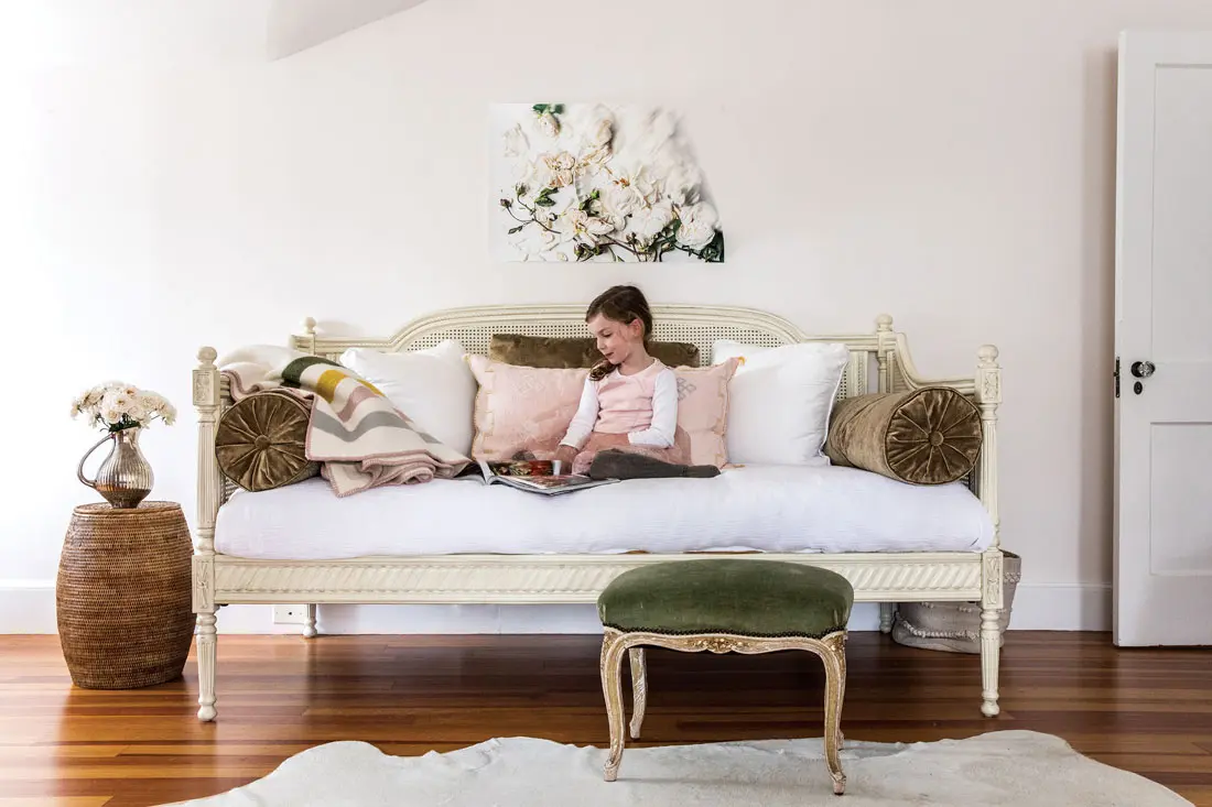 In the sewing room, Josephine relaxes on a Ballard Designs daybed with custom pillows and a wool blanket bought at Blanche + Mimi in Portland.