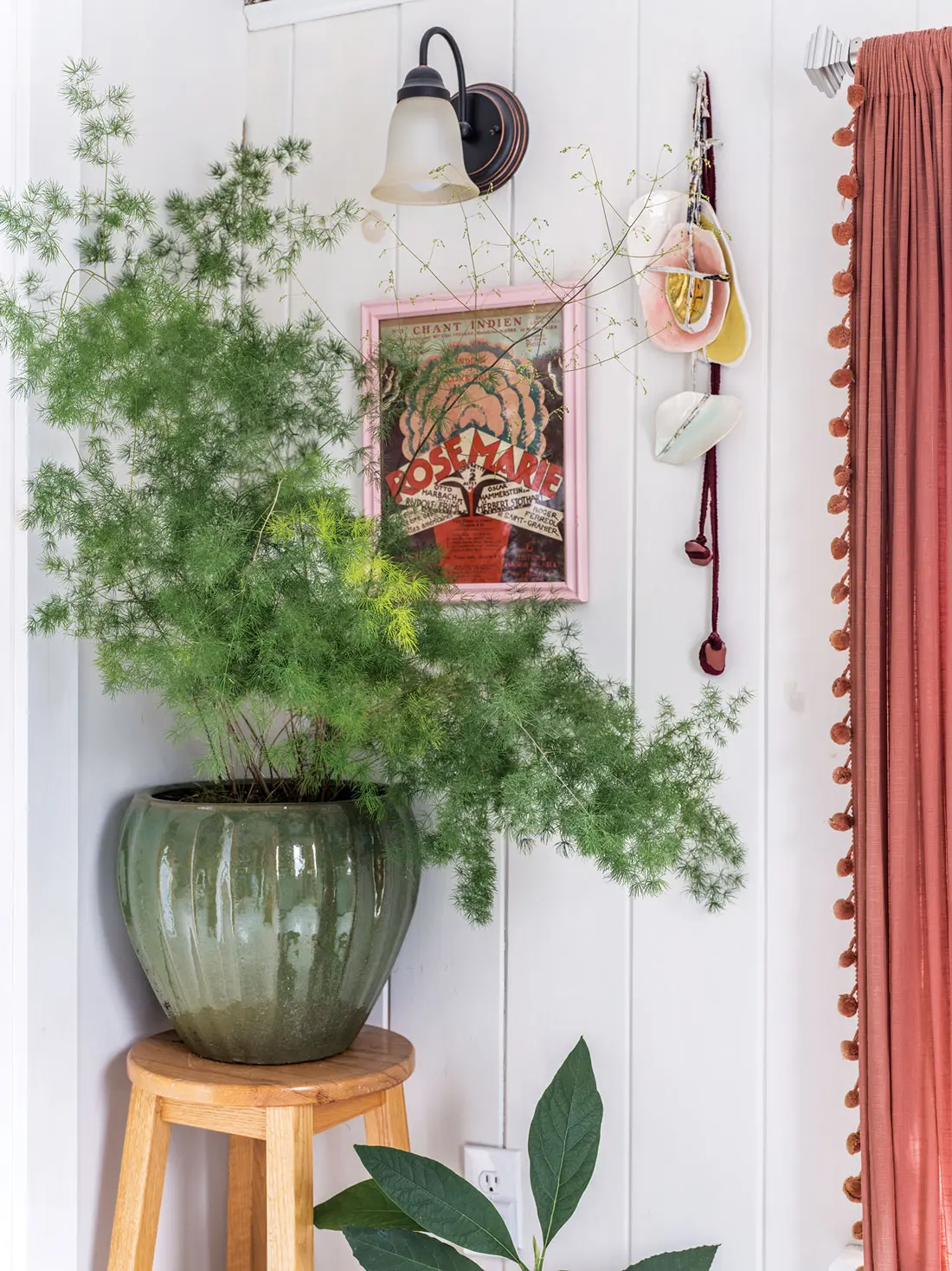 An asparagus fern, an avocado plant, a vintage print from Paris, and a pottery sculpture by Watka form a botanical quartet in the primary bath.