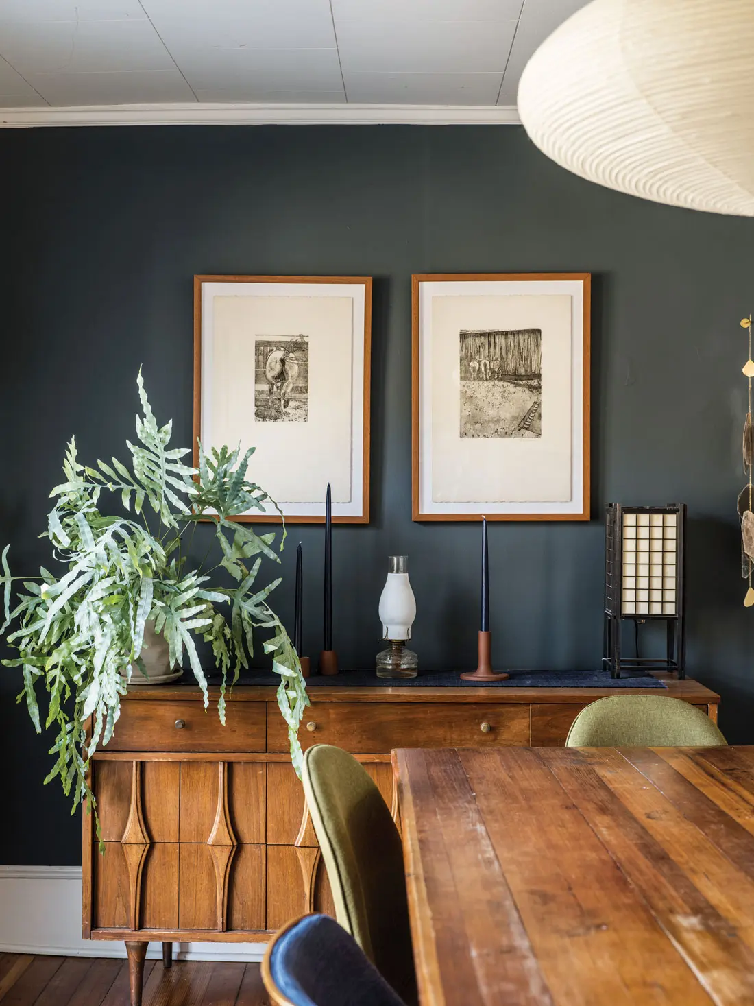 In Christina Watka and Andrew Halchak’s Cape Elizabeth dining room, Behr’s Midnight In Ny backdrops prints by Halchak’s mom, Mary Curran, and a vintage hutch from Portland Flea-for-All.